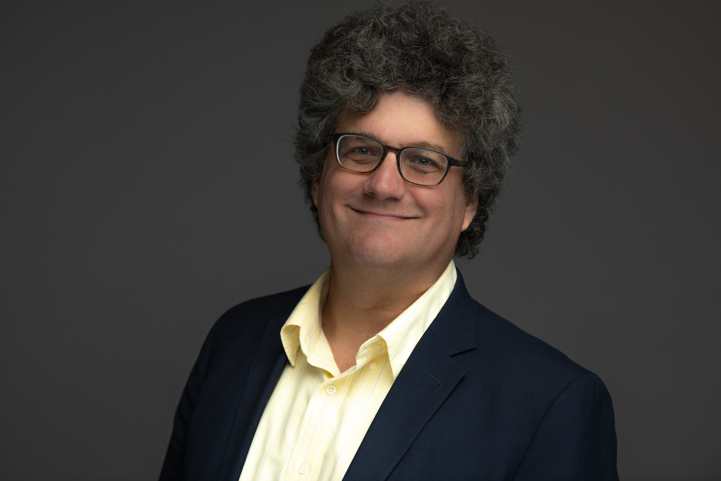 Jonathan Sweedler wearing a black blazer and yellow shirt