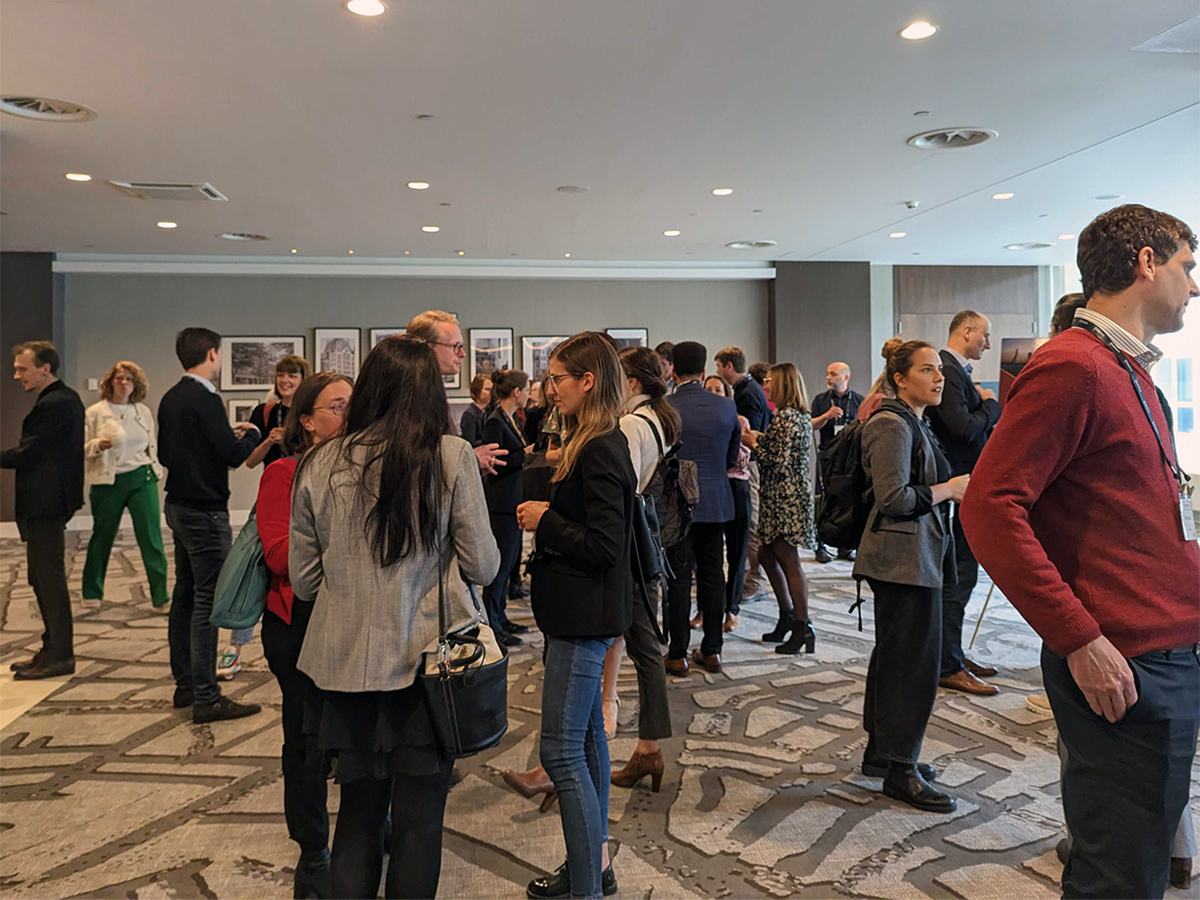 Biopharmaceutical attendees standing in a room networking with peers at the AT Europe Symposium 2023.