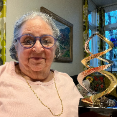 Image of female wearing purple glasses holding a gold award with an inscription 'CASSS Sharing Science Solutions 2023 William S. Hancock Award for Outstanding Achievements in CMC Regulatory Science Kathryn Stein, Ph.D.'