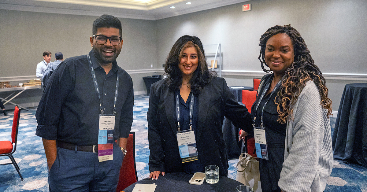 Young biopharmaceutical scientists smiling in conference room at a Symposium.