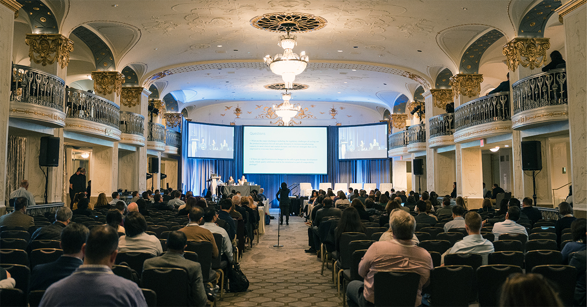 Biopharmaceutical attendees sitting in a large ballroom at the 2023 WCBP Symposium watching a scientific presentation.